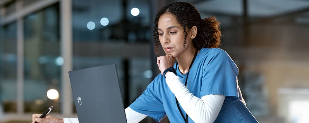 Médica usando notebooks da Positivo para complementar seu trabalho.