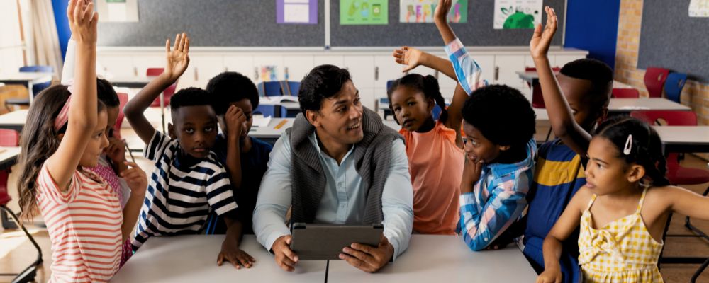 Professor com um tablet ensinando coisas aos seus alunos com a ajuda da tecnologia.