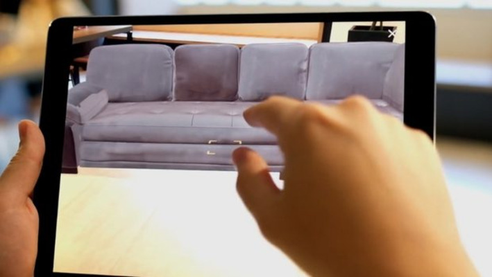 Pessoa usando a realidade aumentada do app da Decora para visualizar como ficariam os móveis em sua sala.