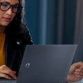 Mulher trabalhando com notebook corporativo da Positivo.