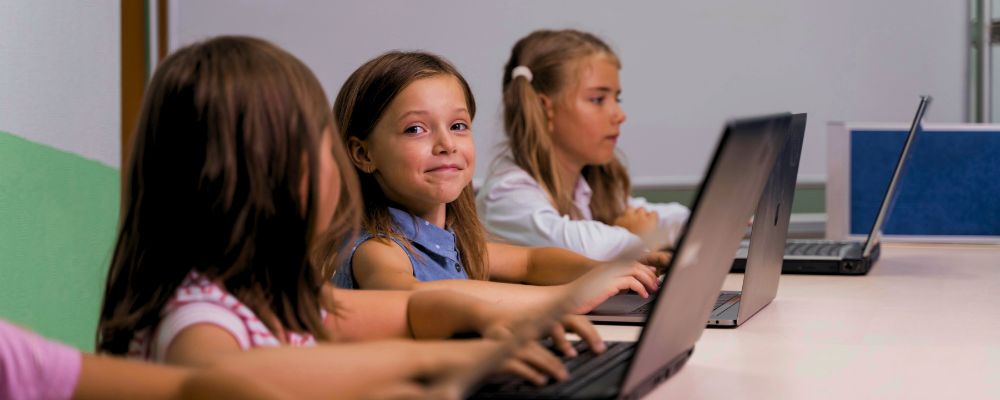 Crianças usando notebooks em sala de aula.