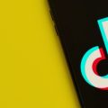 Logo do TikTok sobre um fundo amarelo.