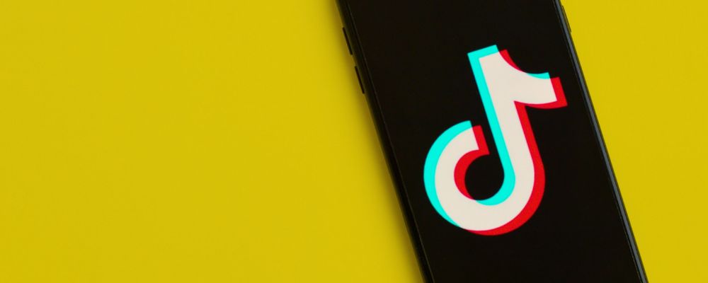 Logo do TikTok sobre um fundo amarelo.