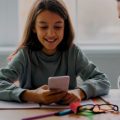 Garota usando o celular em sala de aula.