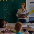 Professora à frente de sua turma de alunos dando uma aula preparada com auxílio do Copilot.