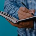 Homem fazendo anotações em um caderno.