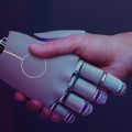 Robô e humano dando as mãos representando o uso de inteligência artificial no nosso dia a dia.