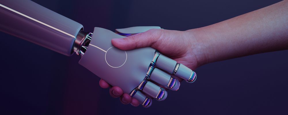 Robô e humano dando as mãos representando o uso de inteligência artificial no nosso dia a dia.