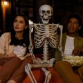 Casal assistindo os lançamentos da Netflix para outubro de 2024 com uma caveira.