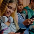 Adolescentes usando redes sociais na escola.