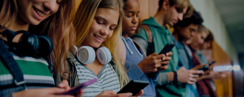 Adolescentes usando redes sociais na escola.