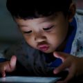 Criança usando apps de leitura em um tablet.