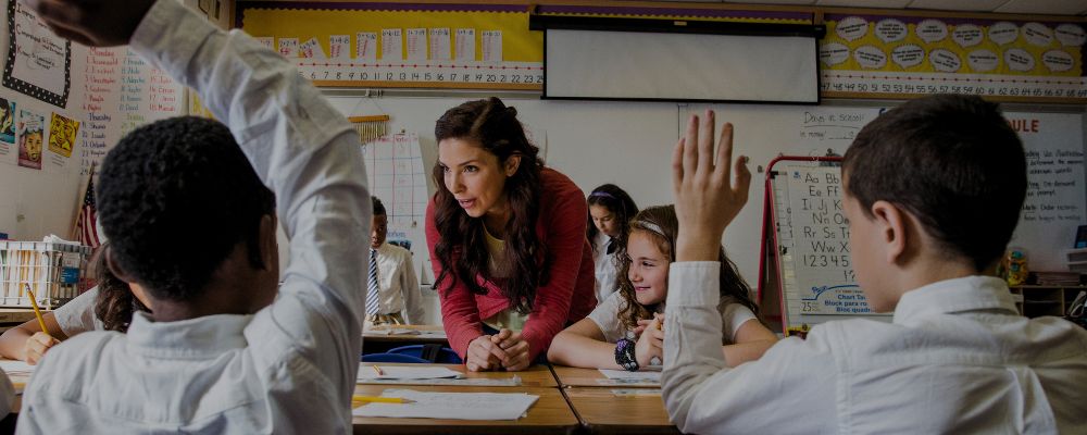 Professora tirando dúvida de seus alunos e incentivando seu aprendizado.