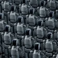 Uma vasta multidão de robôs humanoides idênticos, de cor cinza metálico com detalhes escuros e visores pretos brilhantes, em pé em formação densa. A imagem sugere automação avançada, inteligência artificial e uma força de trabalho robótica em larga escala.